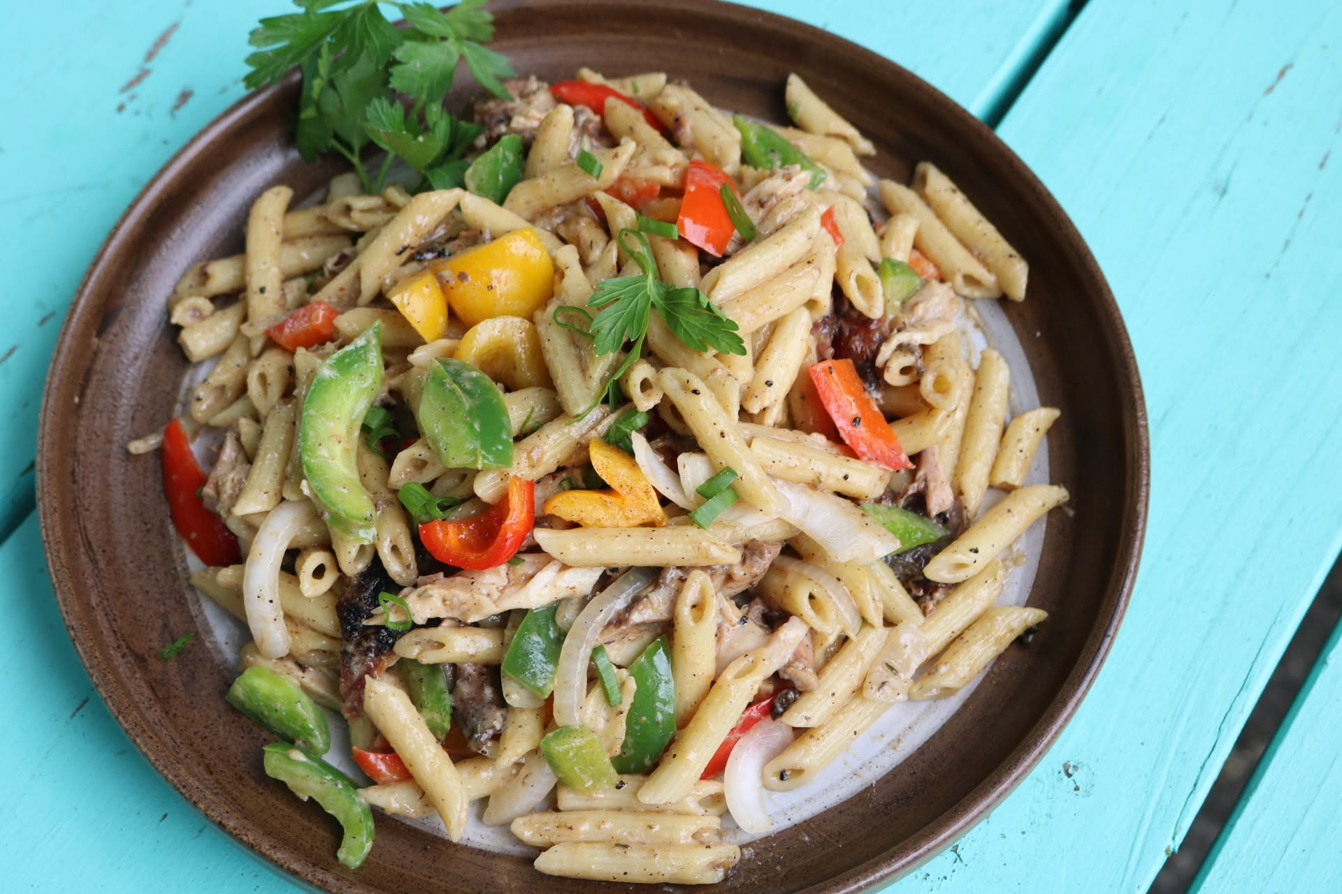 Rasta pasta with peppers in a wooden bowl